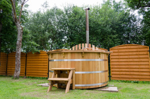 rustic wooden water spa hot tub with stairs in garden yard